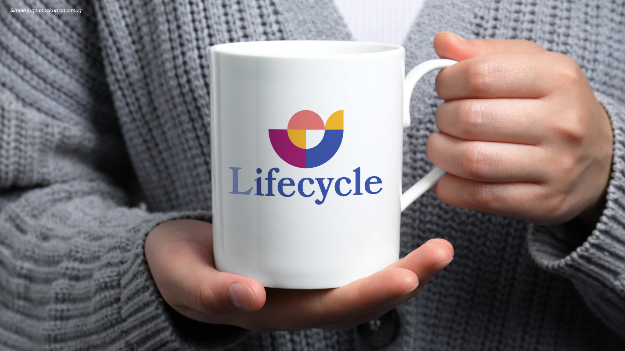 Image of the Lifecycle logo on a mug being held by a woman in a gray sweater